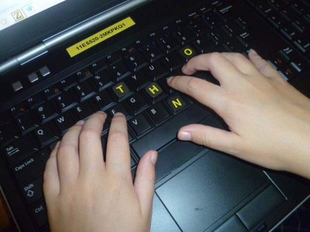 hands positioned on the home keys of a qwerty keyboard.