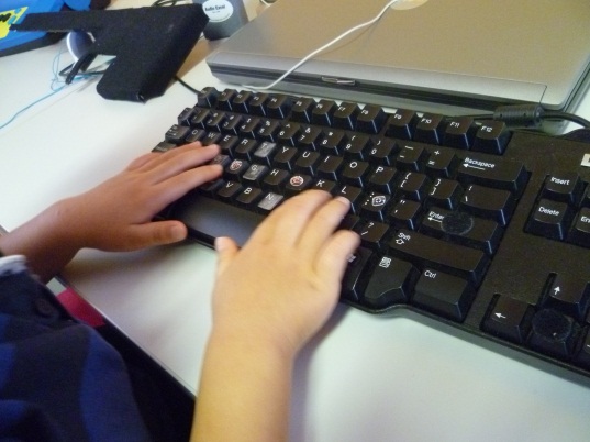 hands placed on a qwerty keyboard.