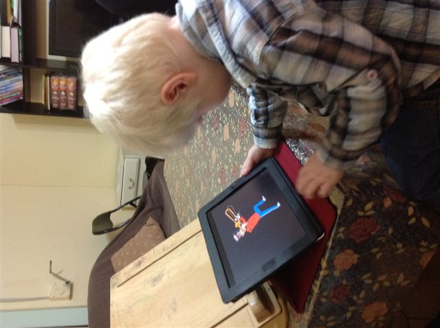 young boy playing a game on the ipad.