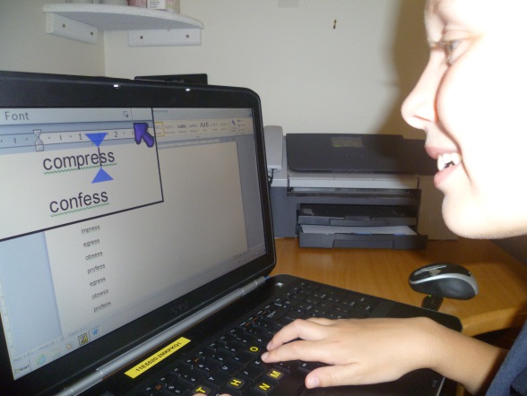 young girl uses screen magnification in a word processor.