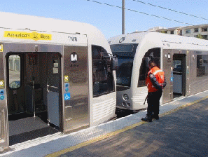 photograph of platform-based transit employee protecting area between light rail vehicles