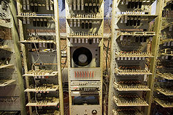 three tall racks containing electronic circuit boards