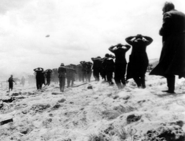 german prisoners of war are led away by allied forces from utah beach.