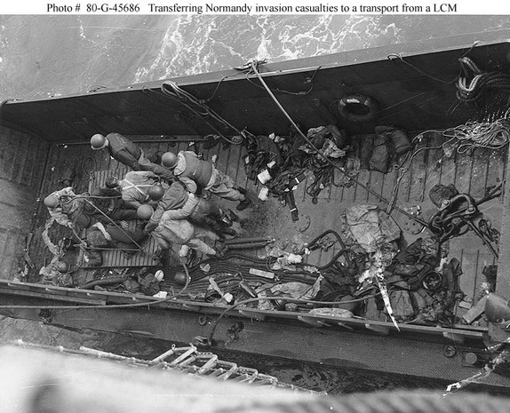 casualties from the initial invasion are transferred from an lcm to a larger ship for evacuation from the normandy area. the photograph was released on june 8, 1944.