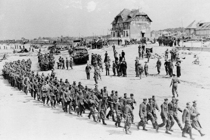 june 6, 1944: german prisoners-of-war march along juno beach landing area to a ship taking them to england, after they were captured by canadian troops at bernieres sur mer, france