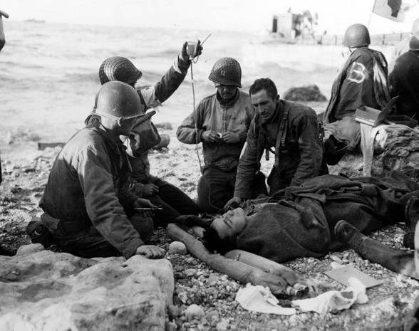 army medical personnel administer a plasma transfusion to a wounded comrade, who survived when his landing craft went down off the coast of normandy in the early days of the allied landing operations.