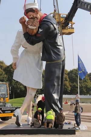 workers hoist and lock together pieces of \'unconditional surrender,\' an 8-meter (25-foot) cast-bronze sculpture in color of a sailor and a nurse in lip-locked embrace, outside the caen memorial on sept. 23 in normandy, france.