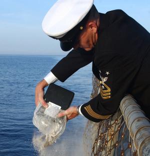 a sailor scattering cremated remains at sea - photo © u.s. navy by chief journalist alan j. baribeau.