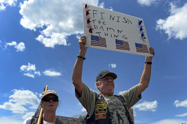 kurt patton and his wife colleen patton, with combat veterans association, holds a sign up as more the 150 veterans and supporters rallied in a parking lot