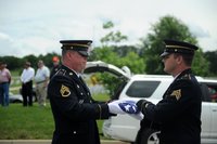 staff sergeant jeff slover, of knoxville, hands a flag to sergeant william broyles, of morristown, during a memorial service for six veterans at the east tennessee veteran\'s cemetery on gov. john sevier highway monday, june 6, 2016.