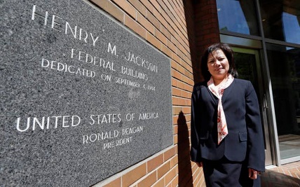 in this photo taken may 12, 2016, commerce department employee c.j. jackson poses for a photo in front of the henry m. jackson federal building where she works, in seattle. jackson, a federal employee who helped expose a fraud in which an army veteran lied his way to a purple heart and hundreds of thousands of dollars in government benefits, was punished for supposedly violating the man\'s privacy. jackson says she\'s spent $20,000 on legal fees to fight off the discipline.