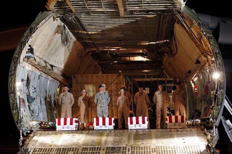 the transfer cases containing the remains of army pfc. michael c. olivieri, left, of chicago; army pfc. christopher b. fishbeck of victorville, calif.; army pfc. michael b. cook of middletown, ohio; and army pfc. emilio j. campo jr. of madelia, minn., sit inside an air force c-5 cargo plane upon arrival at dover air force base. they died supporting operation new dawn in iraq, the military said. associated press (2011)