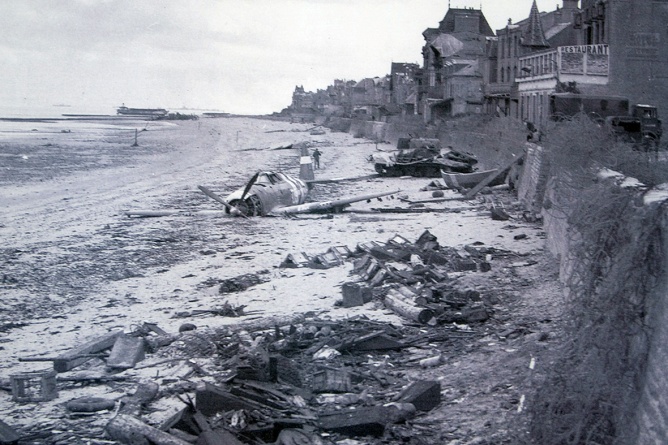 june 194: a crashed us fighter plane is seen on the waterfront some time after canadian forces came ashore on a juno beach d-day landing zone in saint-aubin-sur-mer, france