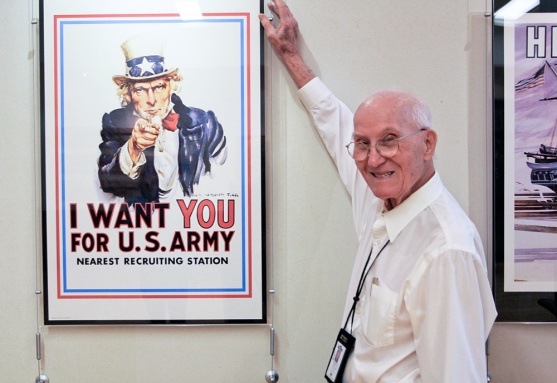 elderly man standing with a poster of uncle sam