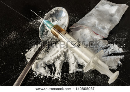 drug syringe and cooked heroin on spoon