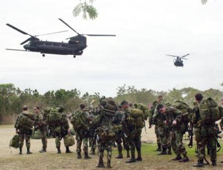 two u.s. mh-47e chinook helicopters prepare to land to pick up members of the u.s. special forces at a military base in the philippines.