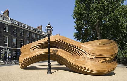 a picture of a curvy timber sculpture in a square