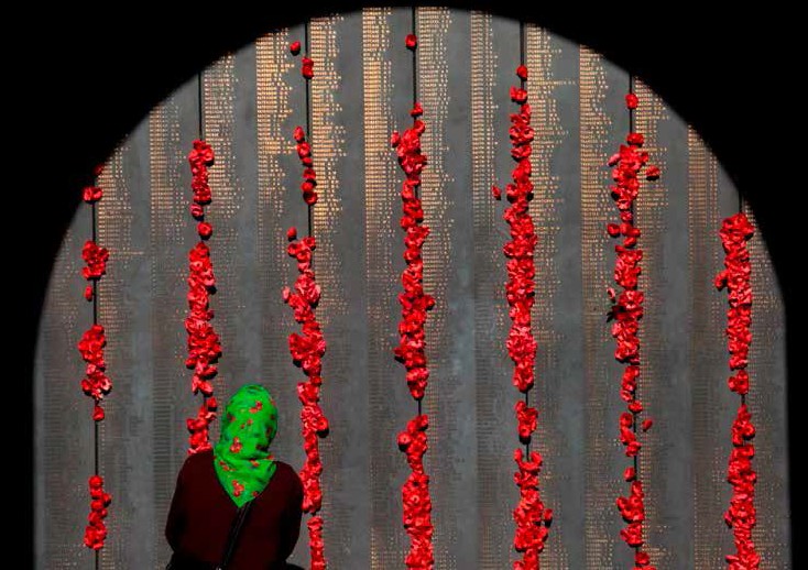 a woman in front of the wall of rememberance